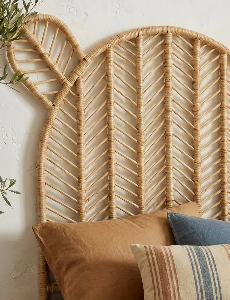 Woven headboard with decorative pillows against a white wall
