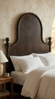 Bedroom with wooden headboard and white bedding