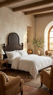 Cozy bedroom with wooden beams, a bed with white bedding, and decorative elements.