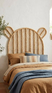 Woven headboard with animal ears on a bed with colorful bedding.
