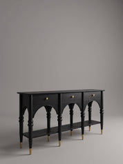 Dark teak wood console with hand-carved wooden studs and cylindrical peg legs, on grey background