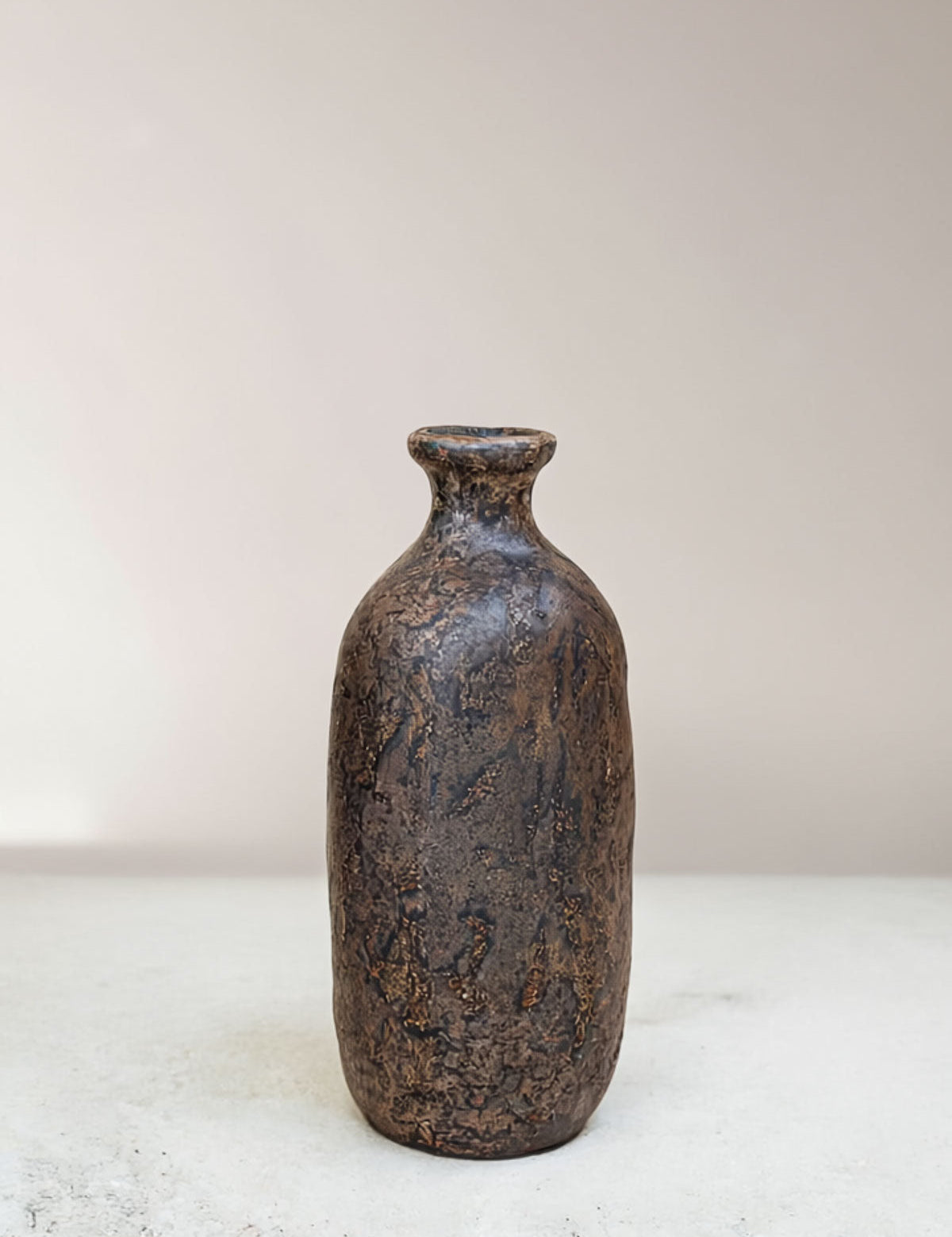 Textured brown ceramic bottle on a light background