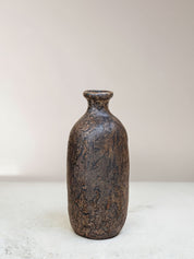 Textured brown ceramic bottle on a light background