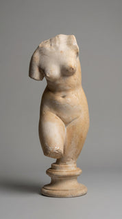 Marble statue of a nude figure on a gray background
