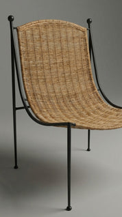 Wicker chair with black metal frame on a gray background