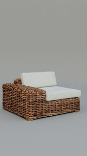 Wicker outdoor chair with white cushion on a gray background