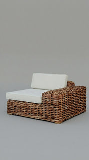 Wicker outdoor chair with white cushion on a gray background