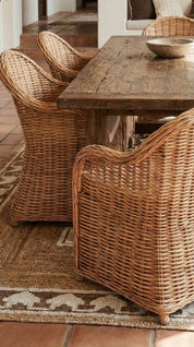 Wooden table with wicker chairs in a rustic setting