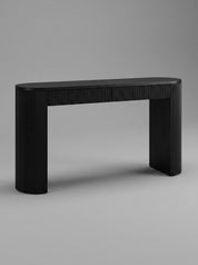 Modern console table blending black wood and fluted rattan detailing with a curved rounded end. A sculptural entryway piece handmade in Bali.