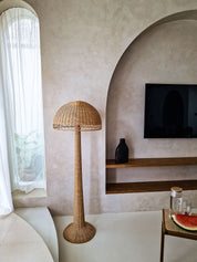 Rattan floor lamp in a living room with a television and decorative items.
