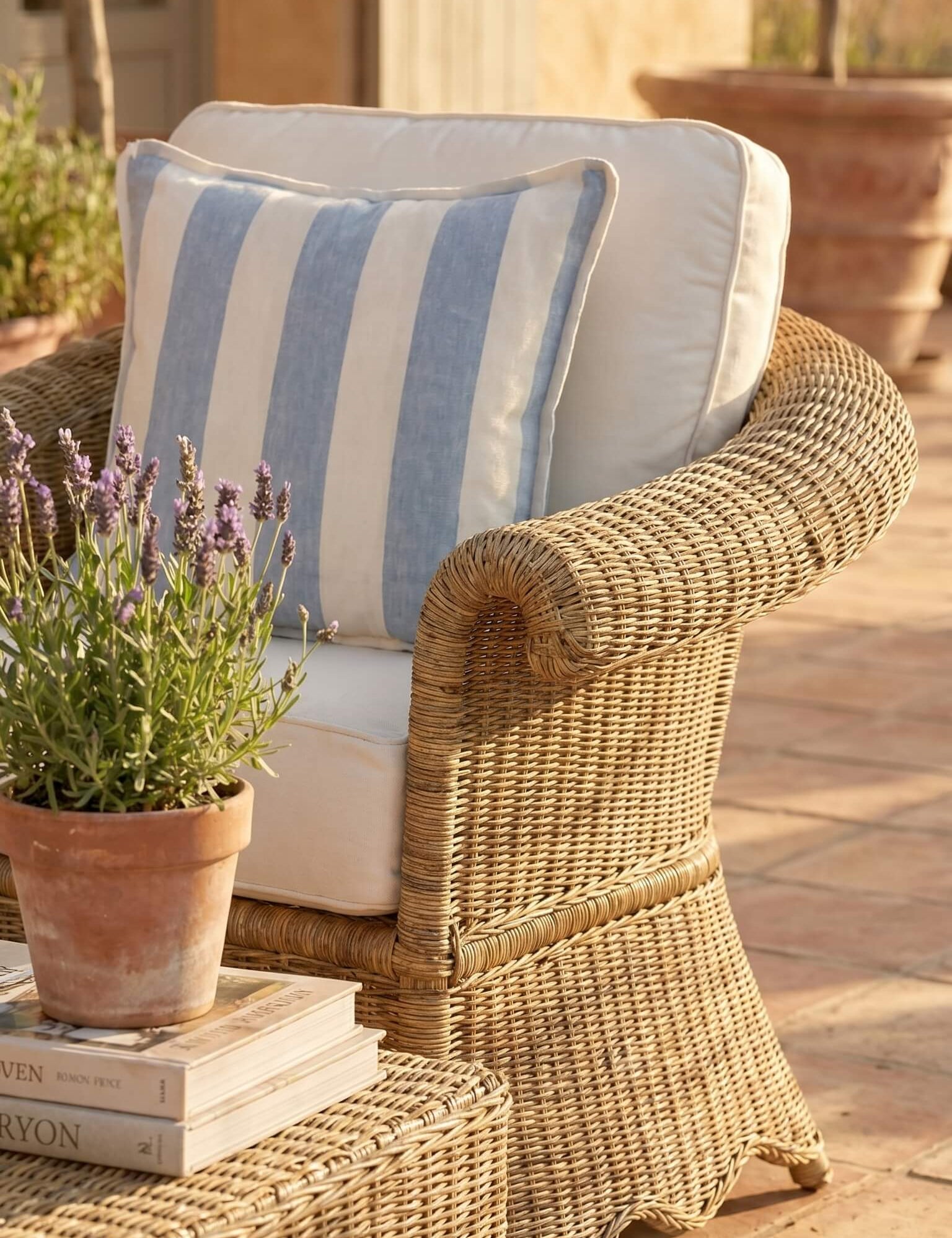 Wicker chair with striped cushion and lavender plant on a patio