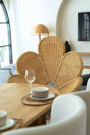 Wicker chair with a modern interior setting, featuring a table with a cup and glass.