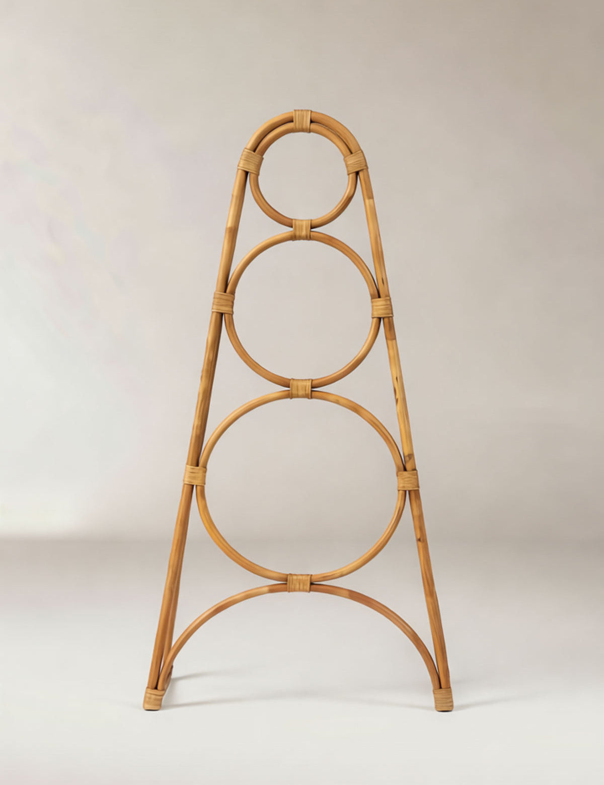 Rattan decorative stand with circular design on a plain background