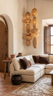 Living room with beige sectional sofa, decorative pillows, and hanging woven lanterns.