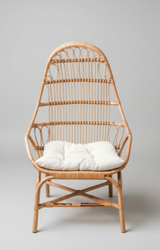 Wicker chair with a white cushion on a gray background