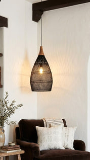 Woven pendant light hanging above a brown sofa with decorative pillows in a cozy living room.