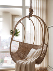 close up on white rattan hanging chair with rounded base