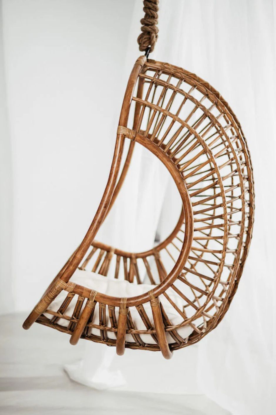 Hugo Rattan Hanging Chair in natural, cognac and brown rattan, handmade, eco-friendly, zero plastic, boho style, perfect for living room, terrace, or patio, stylish and comfortable swinging chair for modern or island-inspired interiors.