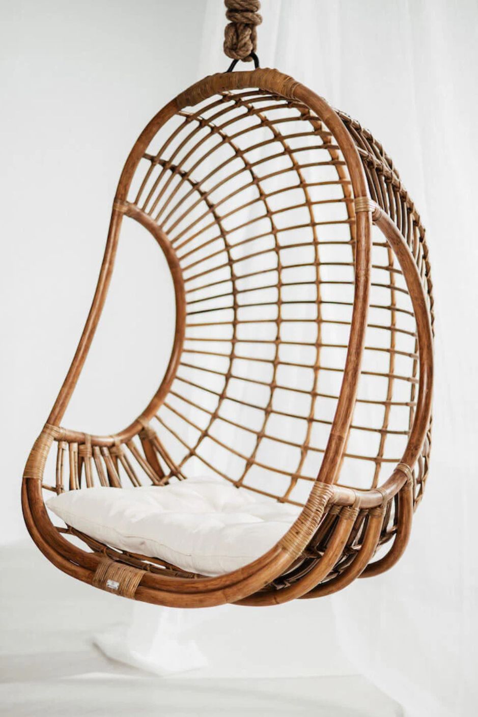 Hugo Rattan Hanging Chair in natural, cognac and brown rattan, handmade, eco-friendly, zero plastic, boho style, perfect for living room, terrace, or patio, stylish and comfortable swinging chair for modern or island-inspired interiors.