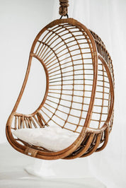 Hugo Rattan Hanging Chair in natural, cognac and brown rattan, handmade, eco-friendly, zero plastic, boho style, perfect for living room, terrace, or patio, stylish and comfortable swinging chair for modern or island-inspired interiors.