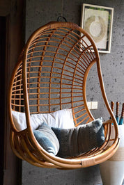 Hugo Rattan Hanging Chair in natural, cognac and brown rattan, handmade, eco-friendly, zero plastic, boho style, perfect for living room, terrace, or patio, stylish and comfortable swinging chair for modern or island-inspired interiors.