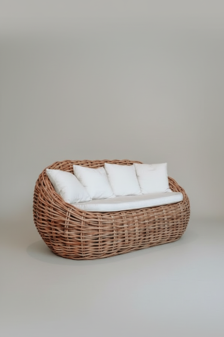 Wicker chair with white cushions on a plain background