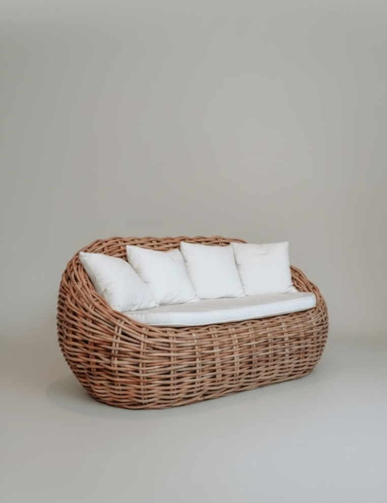 Wicker chair with white cushions on a plain background