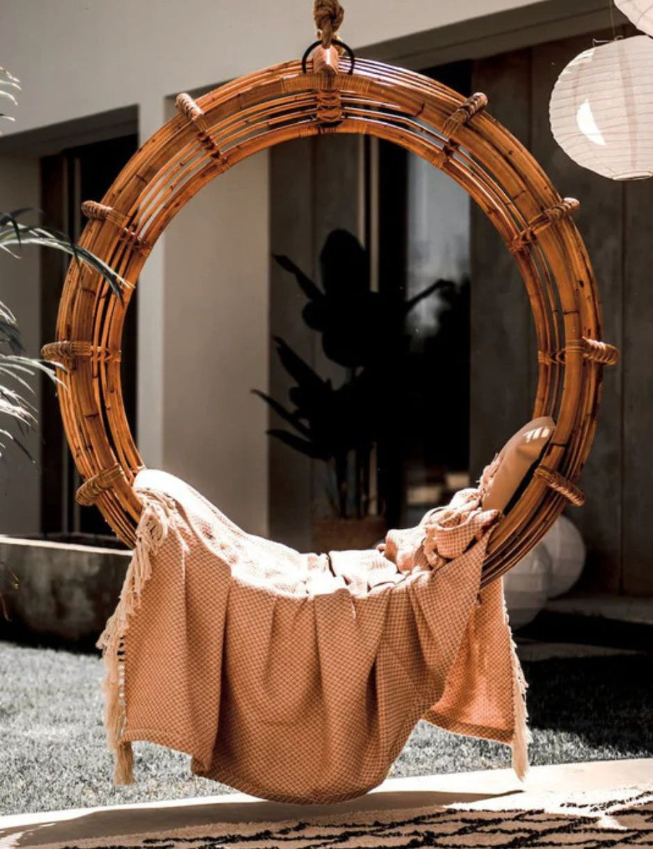 Durable handmade cognac rattan hanging swing chair single, designed for relaxing indoor or outdoor comfort.