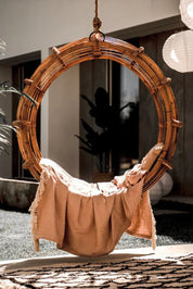 Durable handmade cognac rattan hanging swing chair single, designed for relaxing indoor or outdoor comfort.