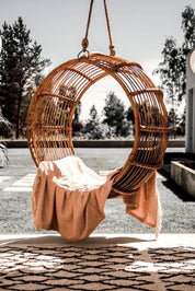 Durable handmade cognac rattan hanging swing chair single, designed for relaxing indoor or outdoor comfort.