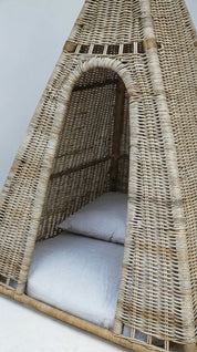 Wicker egg-shaped chair with cushions on a light gray background