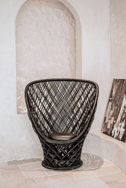 Woven black chair in a room with light-colored walls and floor.