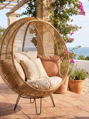 Rattanround chair styled beside lounge chair
Handcrafted rattan chair with woven texture