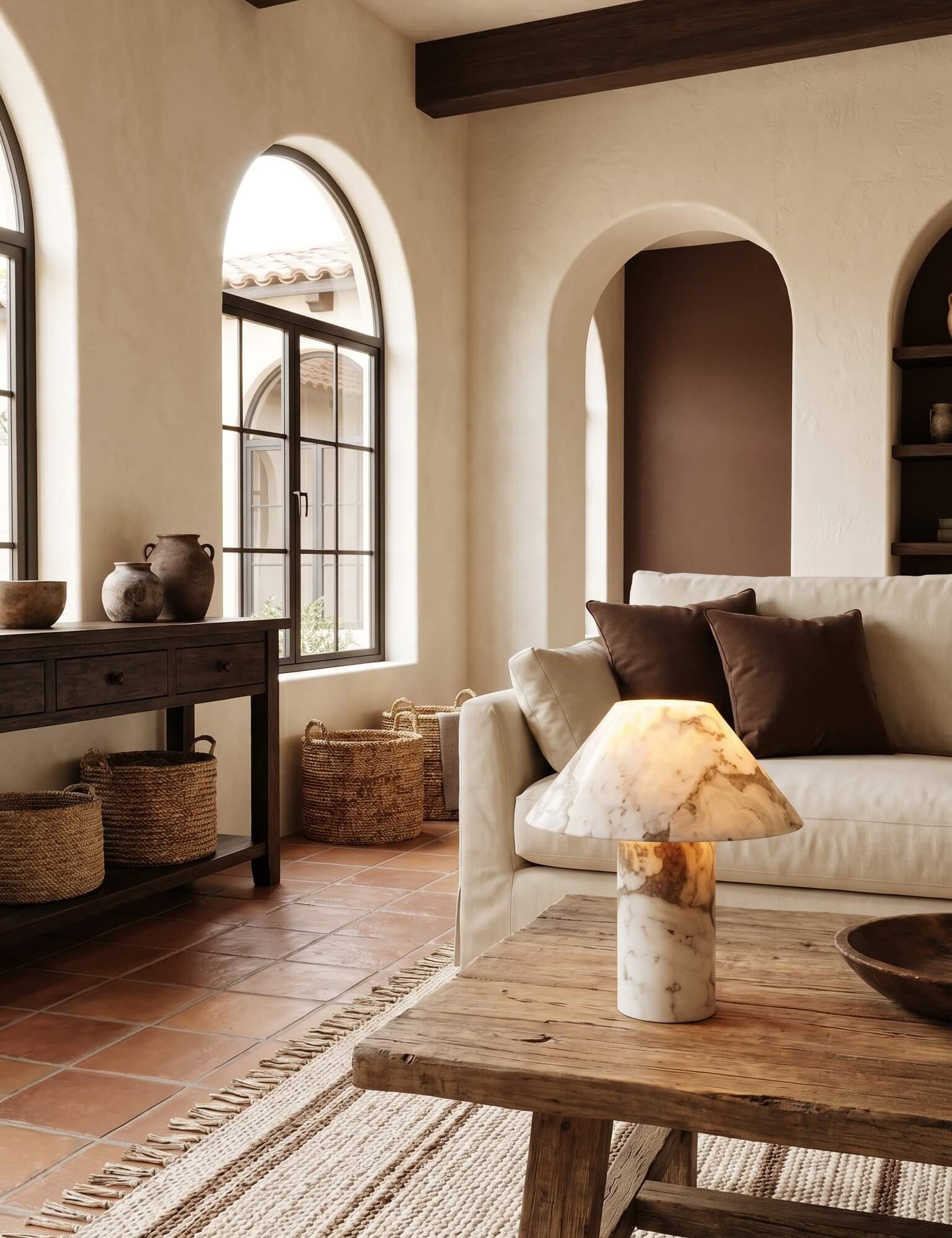 Living room with rustic decor, including a sofa, coffee table, and arched windows.