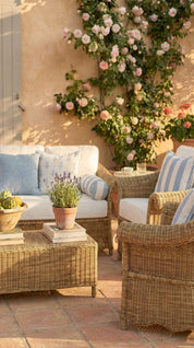Outdoor patio with wicker furniture, flowers, and a stone wall.