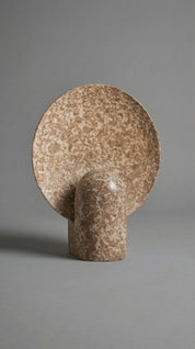 Brown ceramic wall hook on a gray background