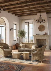 Cozy living room with wicker furniture, fireplace, and large windows.