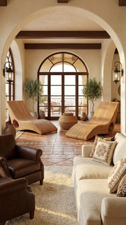 Luxurious living room with wooden lounge chairs, beige sofa, and arched door.