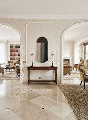 Luxurious interior with marble flooring, a console table, and armchairs.