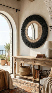 Rustic interior with a round woven mirror and wooden console table.