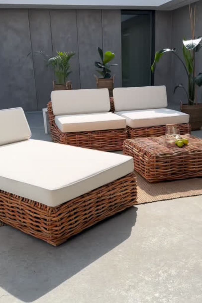 Outdoor wicker furniture set with beige cushions on a patio.