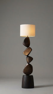 Floor lamp with a unique design featuring stacked stone-like bases on a gray background