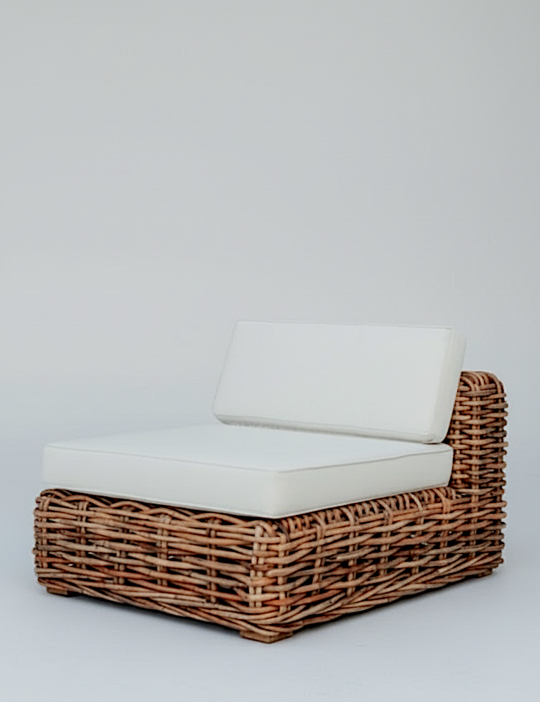Wicker outdoor chair with white cushions on a light gray background