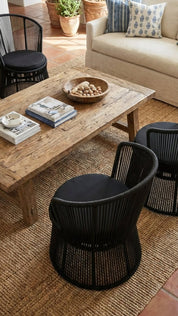 Living room with wooden coffee table, black chairs, and beige sofa.