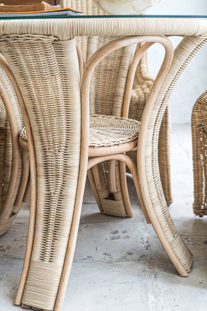 Oriana Ori round rattan table with woven shelf and braided legs, topped with thick glass, showcasing handcrafted natural rattan design and artisanal details