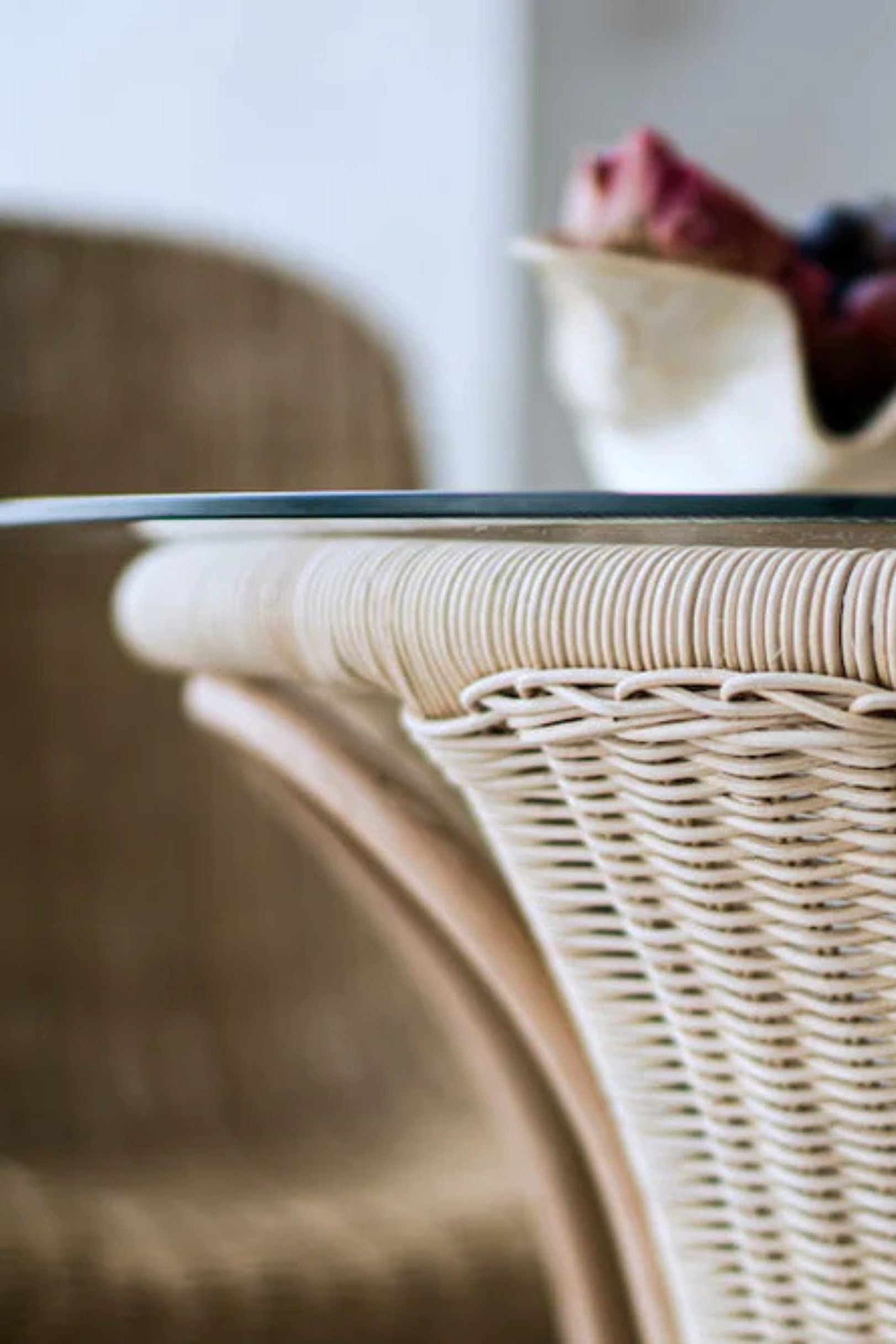 Oriana Ori round rattan table with woven shelf and braided legs, topped with thick glass, showcasing handcrafted natural rattan design and artisanal details