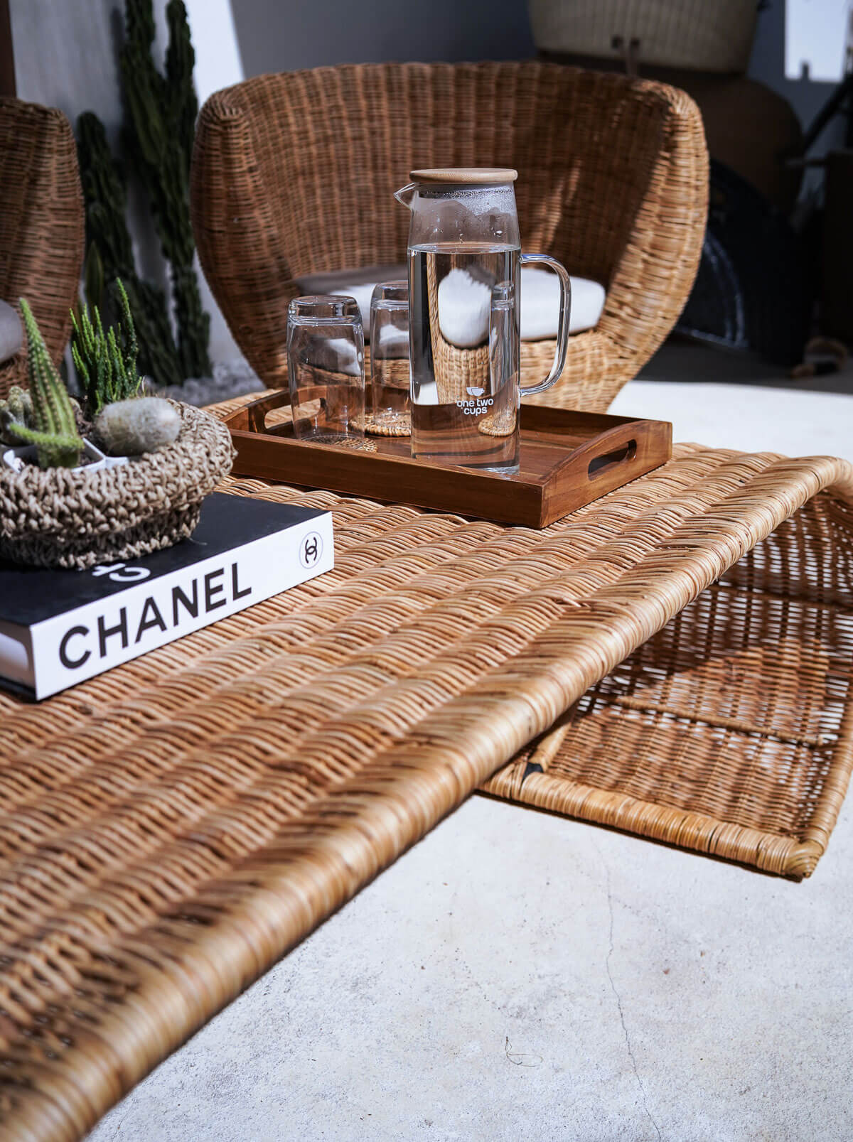 Rattan side table styled beside lounge chair
