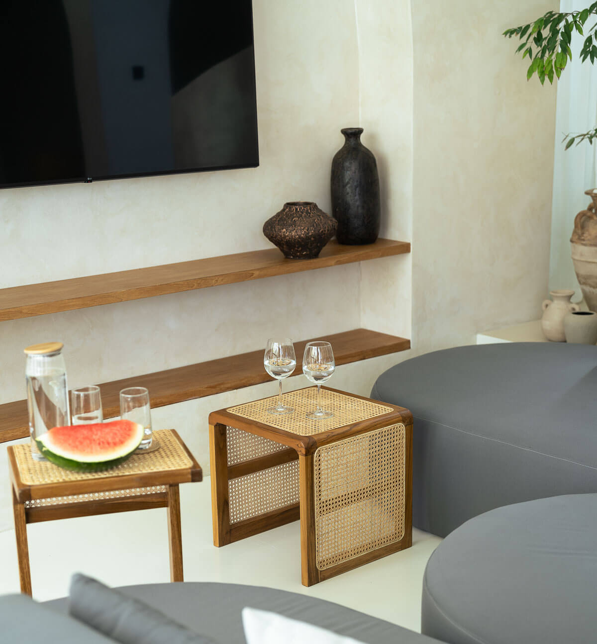 Modern living room with wooden side table, gray sofa, and decorative items.