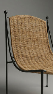 Chair with wicker backrest and black metal frame on a gray background