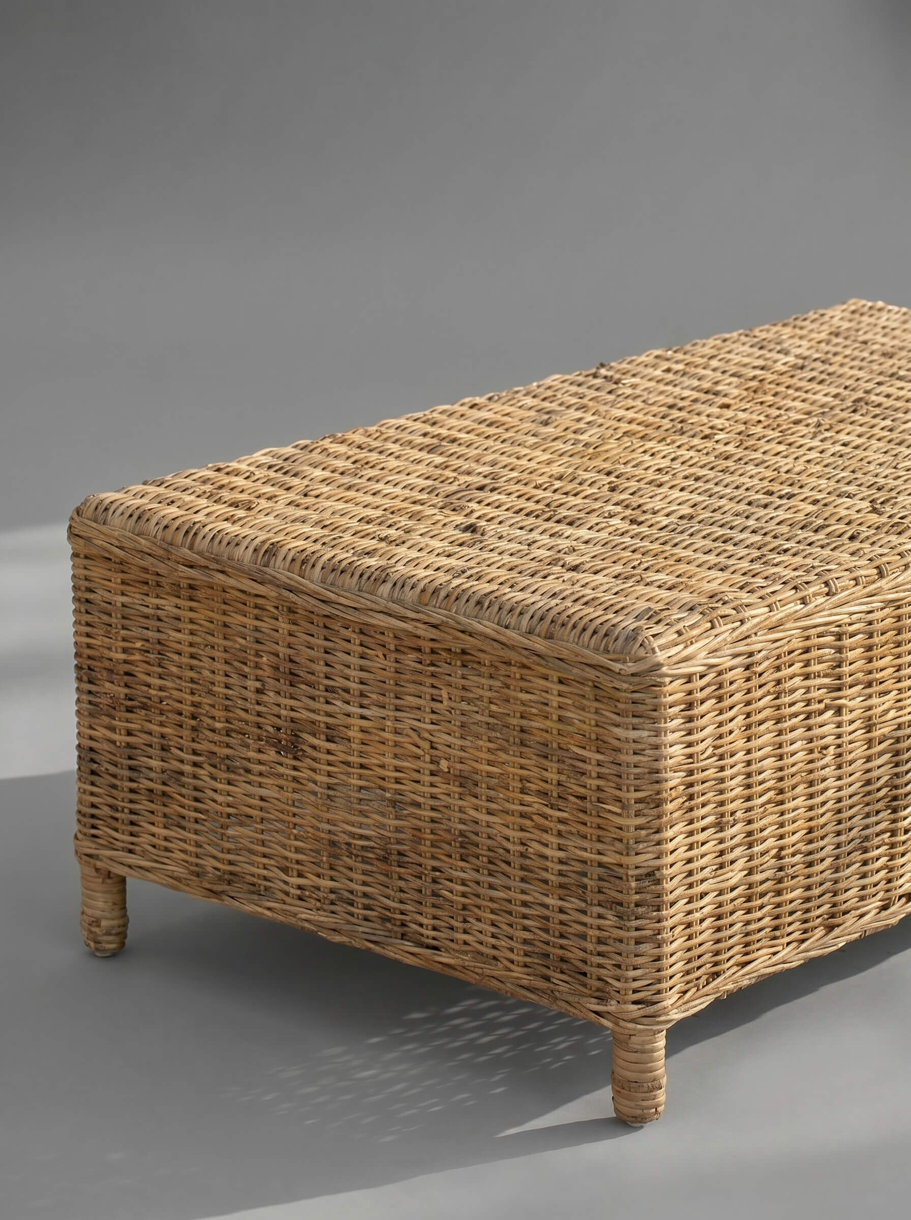 Wicker storage bench on a gray background